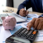 Homem fazendo cálculo na calculadora, com um porquinho de dinheiro ao lado