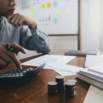 Homem fazendo calculo com calculadora
