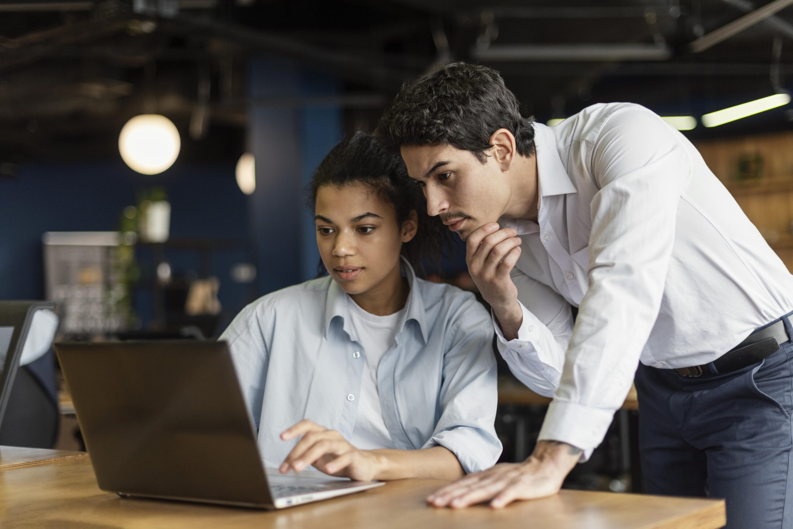 Um homem e mulher olhando para o notebook